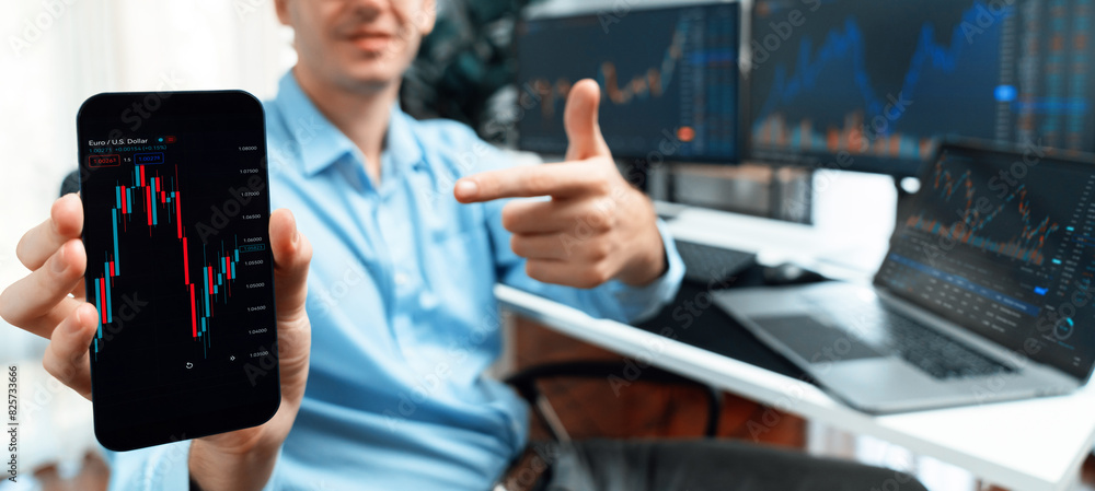 Poster successful young business trader showing dynamic stock market graph on smartphone, presenting infoma