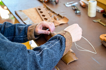 Traditional crafts from sewing leather, tailoring clothes or bracelets with string, needle and...