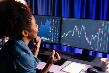 African woman blogger exited with happy face, pointing on screen with valued stock market...