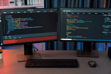 Programming code on computer two screens on desktop placing working desk showing intelligent...