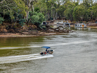 Canopied Boat Speeding Up The River