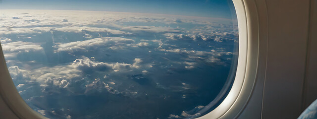 A portrait and close up image of an airplane window seat with sky view visible through the window, copy space
