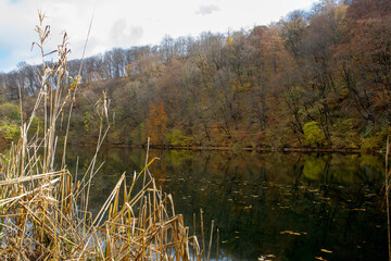 autumn day on a mountain lake of karst origin surrounded by a yellowing forest