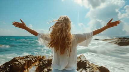 Woman with arms outstretched on the beach.
