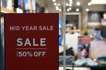 Sign announces start of sale in supermarkets for shopping. Discount sale label at shop entrance. Sale up to 50 percent, Concept of shopping during discounts on mid year sale.
