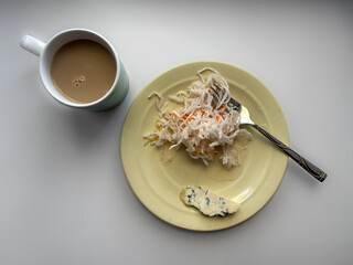 Breakfast is a plate with cabbage, cheese with mold and coffee. Flat Lay