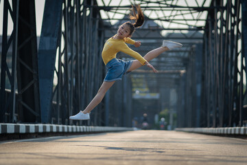 Beautiful girl ballerina dancing. Ballerina Performance Street Show in the city. A teenager poses...