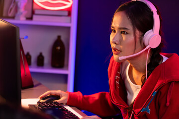Host channel of smiling beautiful Asian girl streamer playing online game wearing headphone talking...