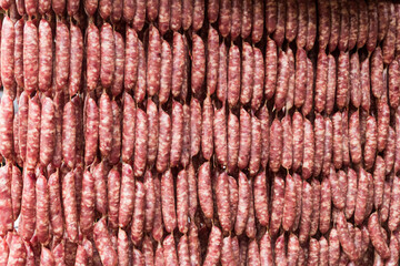 Close-up of ungrilled Taiwanese sausage bunches hanging on wooden sticks. This is one of the street snacks popular among tourists in Taiwan.
