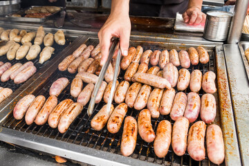Close-up of the vendors grilling Taiwanese sausage and sticky rice (glutinous rice) sausage in the night market in Taiwan. This is one of the street snacks popular among tourists in Taiwan.