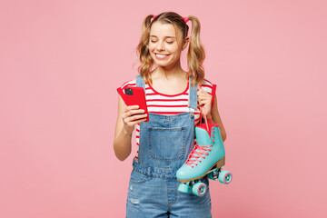 Young happy smiling woman she wear red t-shirt denim overalls casual clothes hold blue rollers use...