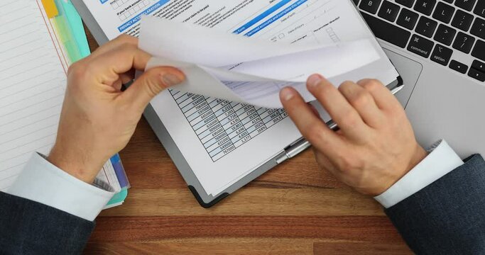 Filling out documents and businessman studying contracts