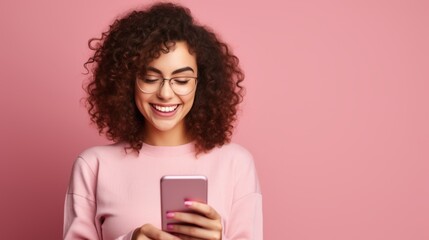 Surprised happy brunette woman with smartphone on pink background. Celebrating Win concept