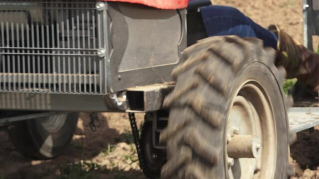 Smiltene, Latvia - May 20, 2024 - Close-up of a muddy tractor tire and agricultural equipment in a field