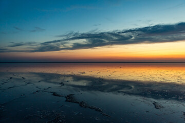 Sunset or sunrise on salt lake Elton (Russia) with mirror or reflection of high Altocumulus or...