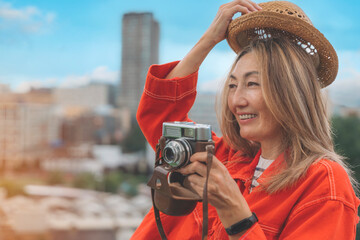 smiling asian woman sitting in front of city Sheffield and take photos 