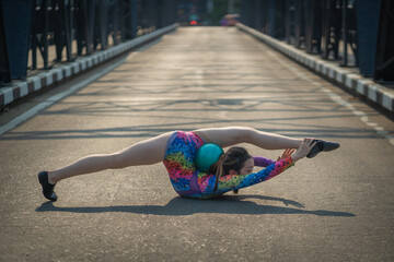 Beautiful Asian girl performs an acrobatic pose. Performance Street Show in the city. A teenager...