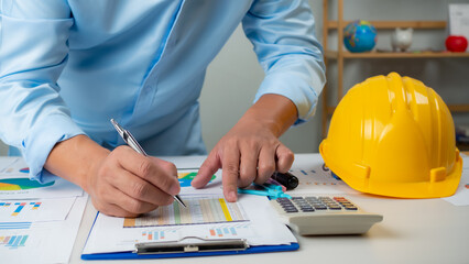 Architect or engineer sitting at desk in office, Cost calculation, Construction planning, structural calculation, Project construction cost planning and calculation, Project presentation plan.