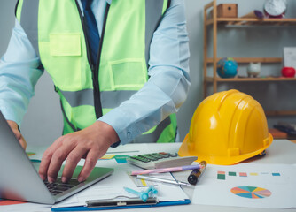 Architect or engineer using computer to work on desk, Cost calculation, Construction planning, Structural calculation, Construction cost planning, Structural design, Project presentation plan.