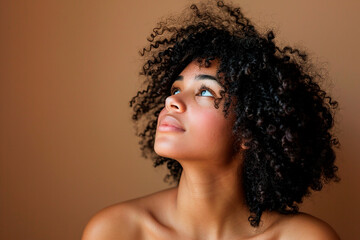 A woman with curly hair is looking up at the camera