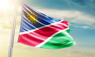 Namibia national flag waving in beautiful sky.