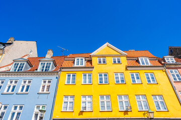 Colorful facades of old houses along Nyhavn embankment in Copenhagen - upward view. Denmark