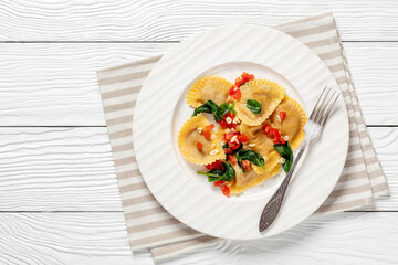 italian pasta mezzelune on a plate, top view
