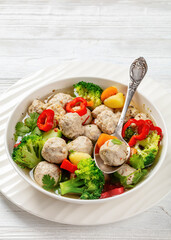 chicken meatball soup with vegetables in a bowl