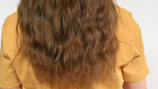 Rear view of Asian woman grab her hair and release it for testing hair healthy. Healthy hair means that your body is producing enough vitamins and nutrients.