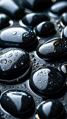 Water dew drops on black stones pebbles macro close-up. Stunning vertical wallpaper background design.