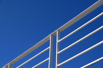 Naklejka premium white painted steel railing on blue sky background