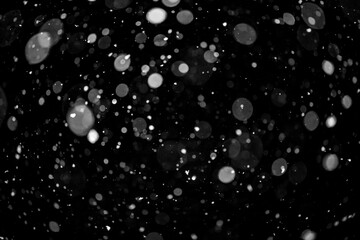  Bokeh lights on black background, shot of flying snowflakes in the air