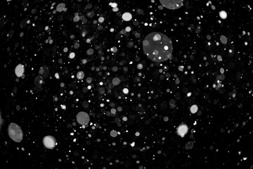  Bokeh lights on black background, shot of flying snowflakes in the air