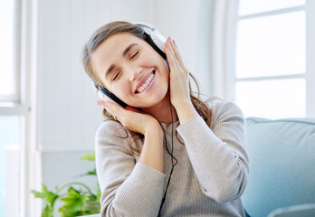 Woman, headphones and happy music in home, relax and subscription for streaming playlist on couch....