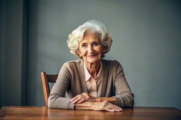 Minimalism. A studio portrait of a stylish, elegant elderly woman, a pensioner of 70 years old, in an interior and clothes of calm tones. The concept of the elderly.