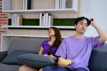 Young couple is watching television in  the living room.