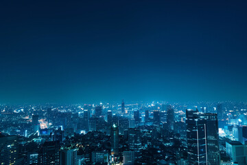 Fototapeta premium City Skyline at Night: Aerial View of Illuminated Skyscrapers