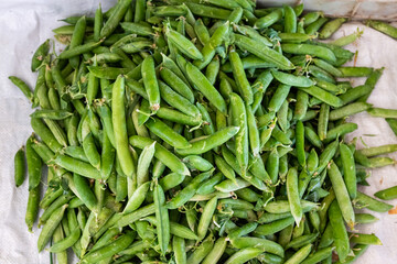 Snow peas at the market. Green peas in the close-up. Fresh organic snow peas for sale at Sunday farm market.