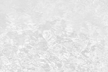 White water with ripples on the surface. Defocus blurred transparent white colored clear calm water surface texture with splashes and bubbles. Water waves with shining pattern texture background.