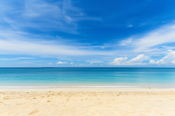 Obraz premium Sunlit Beach with Blue Sky and Ocean View