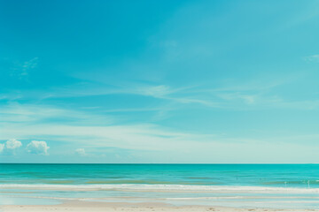 Fototapeta premium Sunlit Beach with Blue Sky and Ocean View