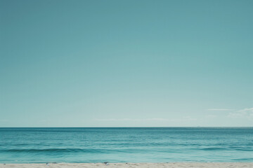 Obraz premium Sunlit Beach with Blue Sky and Ocean View