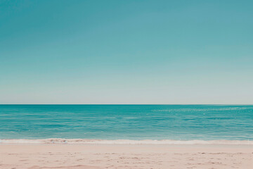 Obraz premium Sunlit Beach with Blue Sky and Ocean View