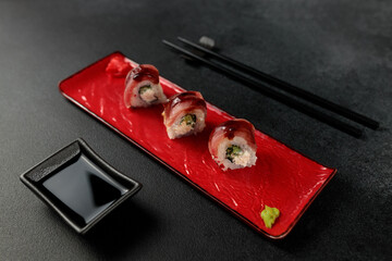 Japanese food: sushi, roll with tuna, tiger shrimp, unagi, Philadelphia. Black background