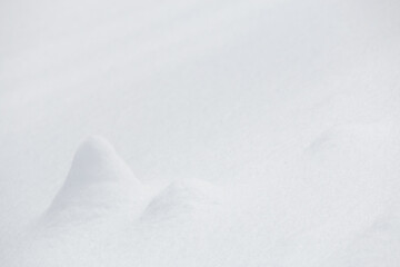 Small mounds of white snow surface in winter landscape background
