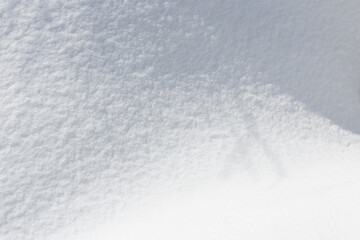 Light and shadow on fresh grainy snow abstract winter background