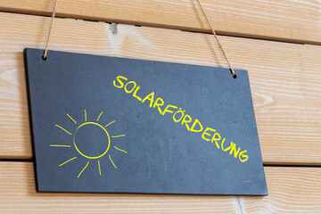 Schild auf einer Holztafel mit der Aufschrift SOLARFÖRDERUNG