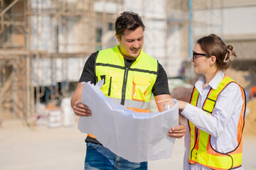 Construction Workers Discussing Blueprint at Building Site
