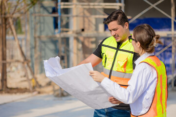 Construction Workers Discussing Blueprint at Building Site