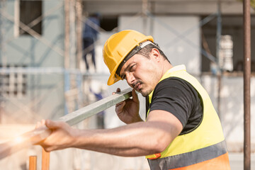 Focused Construction Worker Wearing Hard Hat and Safety Vest